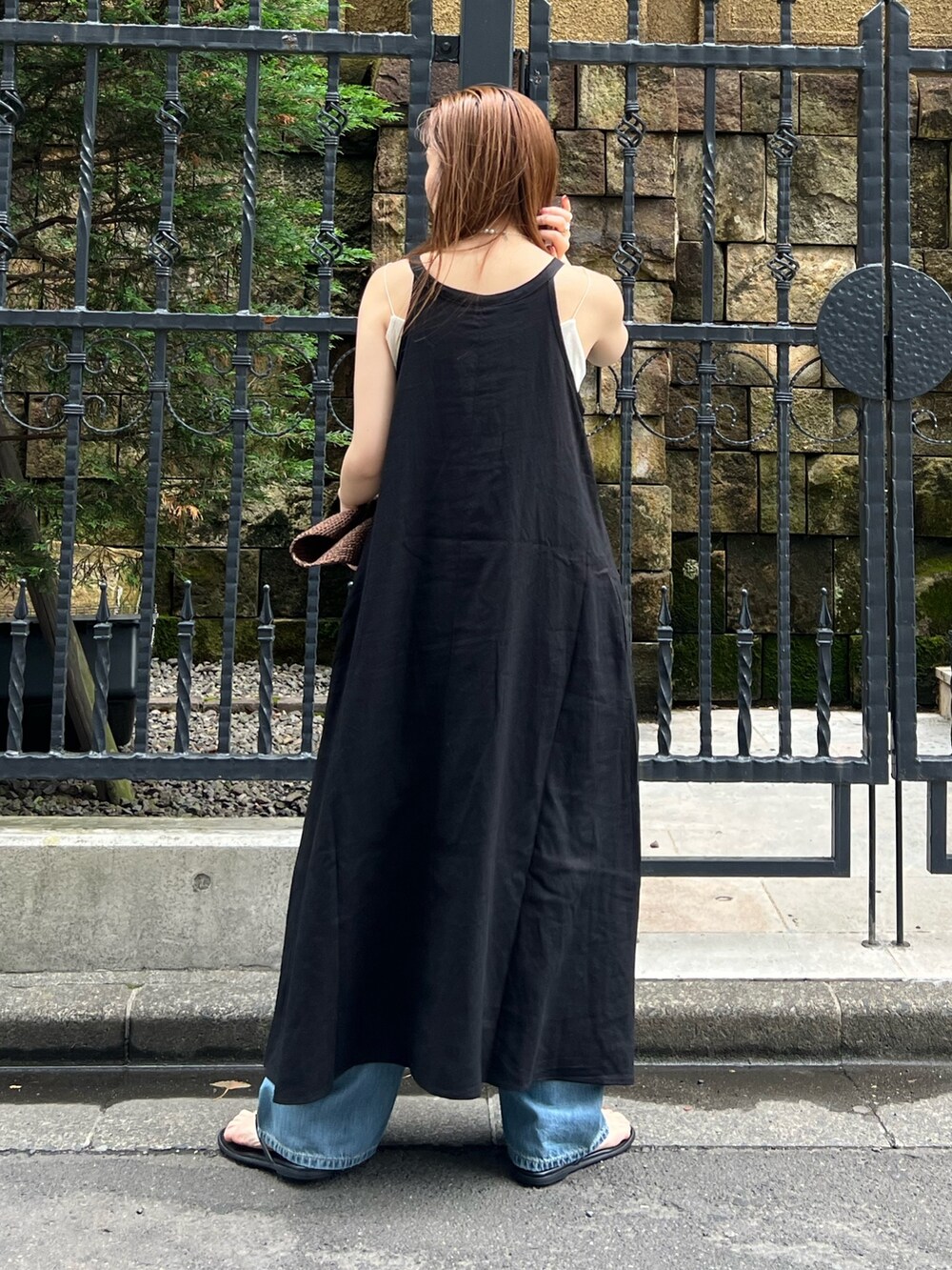 ブラック系のワンピース、ブルー系のデニムパンツ、ホワイト系のキャミソールを着用したレディースの夏コーディネートの5枚目の写真