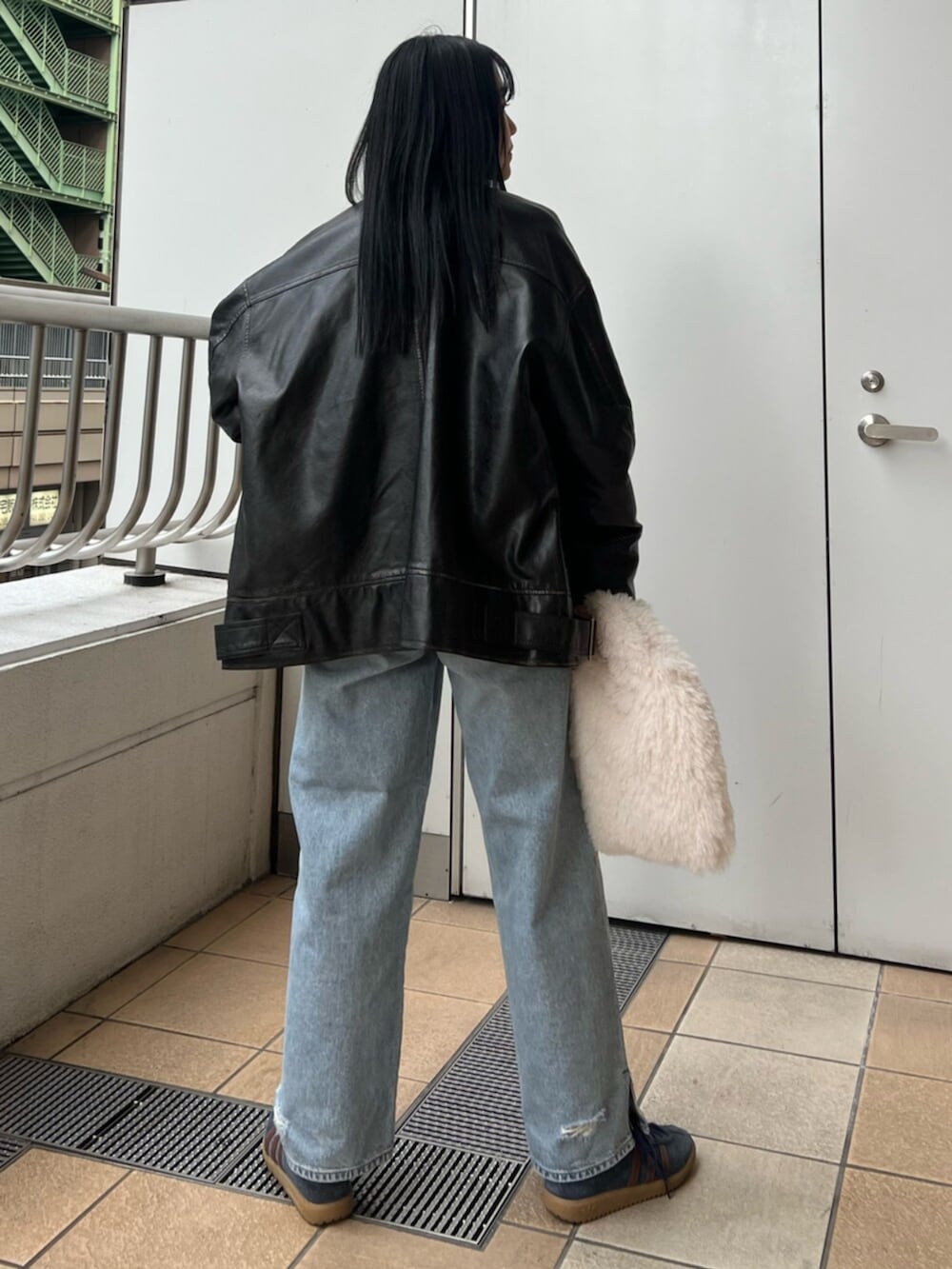 ブルー系のデニムパンツ、ブラック系のブルゾン、ブルー系のシャツ/ブラウスを着用したレディースの冬コーディネートの4枚目の写真