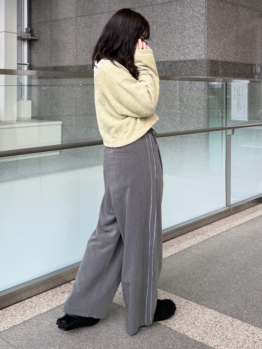 グレー系のその他パンツ、グリーン系のTシャツ/カットソー、ブラック系のスリッポンを着用したレディースの冬コーディネートの4枚目の写真