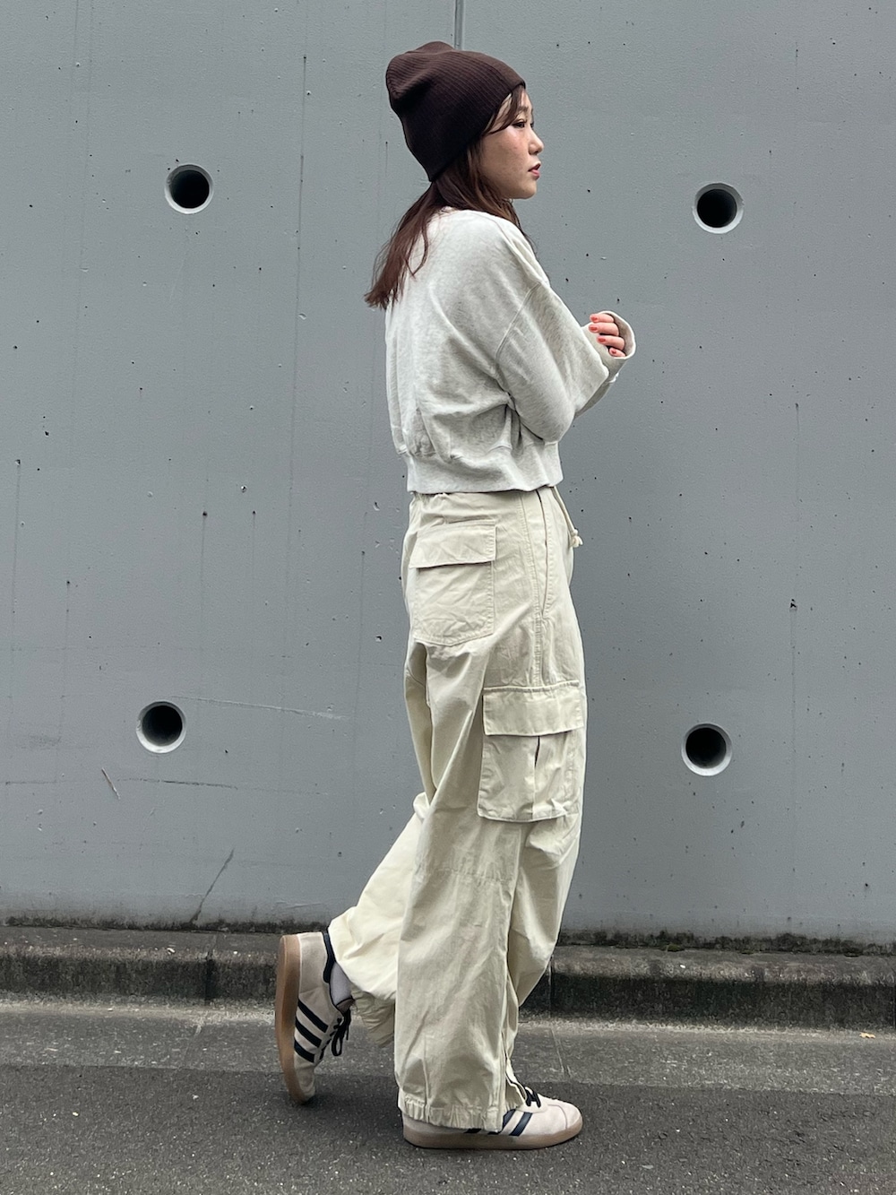 ホワイト系のカーゴパンツ、グレー系のスウェット、ブラウン系のニットキャップ/ビーニーを着用したレディースの秋コーディネートの3枚目の写真