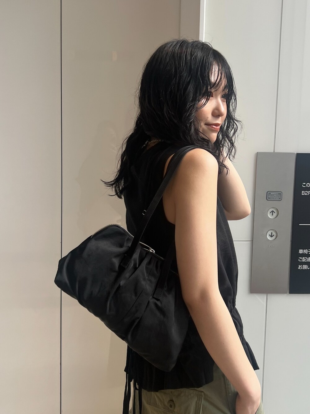 グリーン系のその他パンツ、ブラック系のタンクトップ、シルバー系のサンダルを着用したレディースの春コーディネートの4枚目の写真