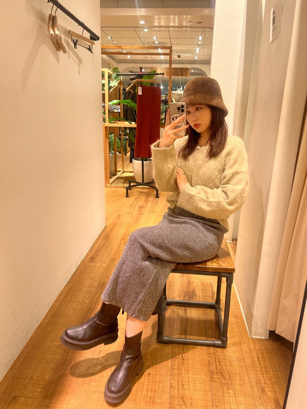 グレー系のニット/セーター、グレー系のスカート、ブラック系のブーツを着用したレディースの冬コーディネートの2枚目の写真