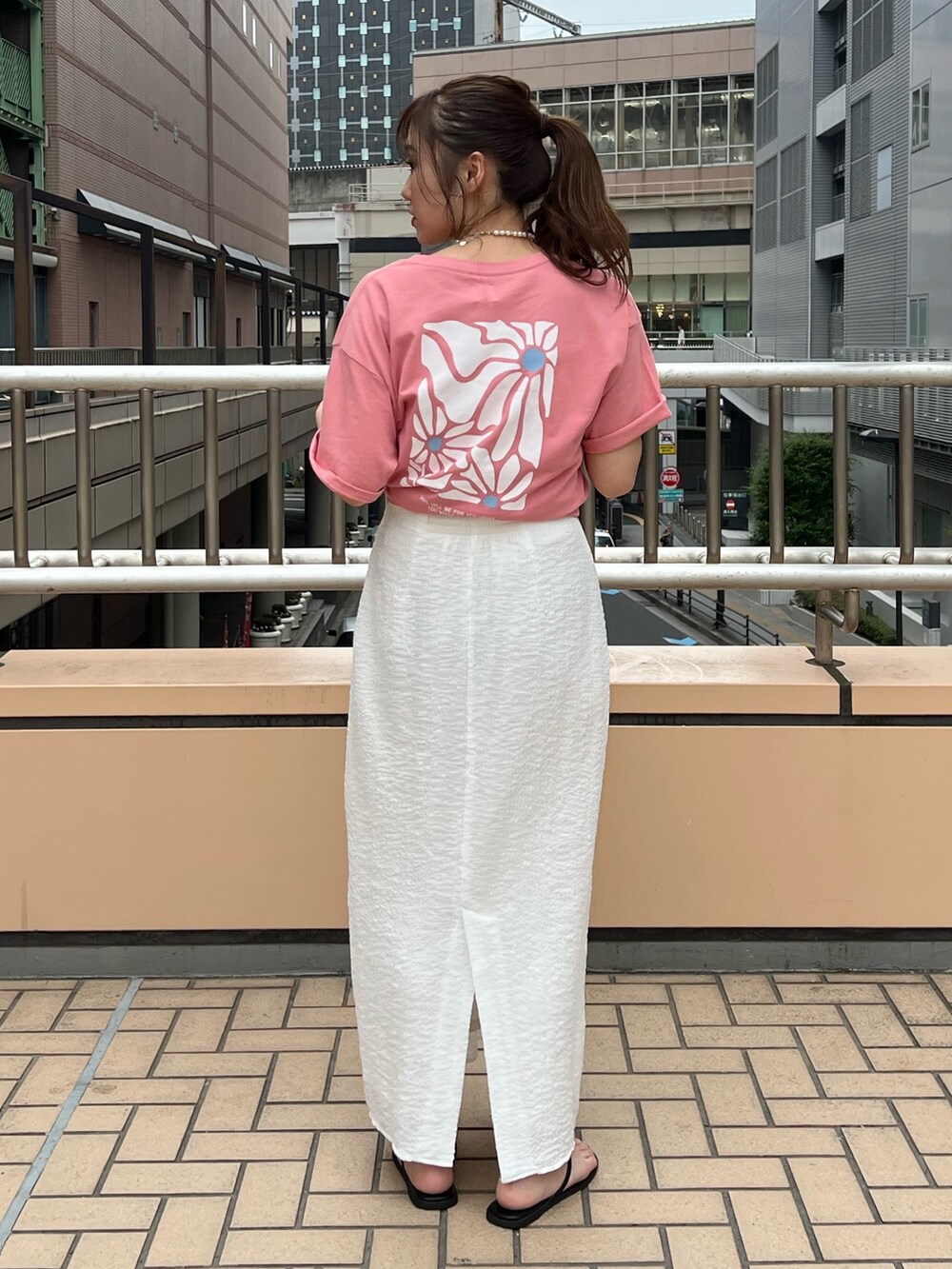ホワイト系のスカート、ピンク系のTシャツ/カットソーを着用したレディースの夏コーディネートの3枚目の写真