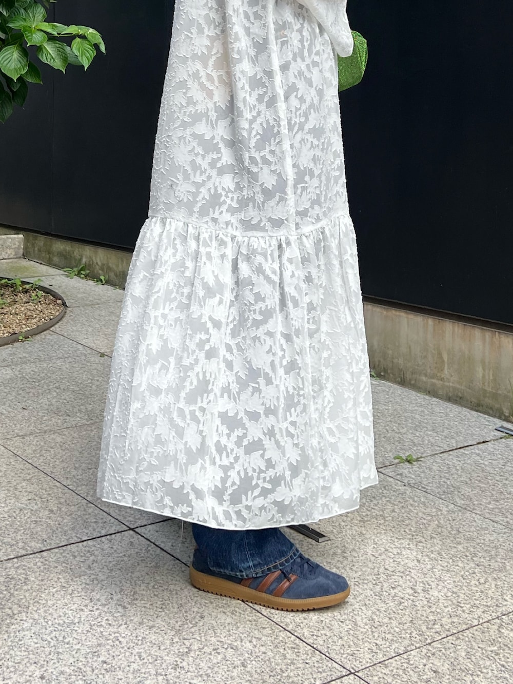 ホワイト系のワンピース、ブラック系のキャミソール、ブルー系のデニムパンツを着用したレディースの秋コーディネートの6枚目の写真