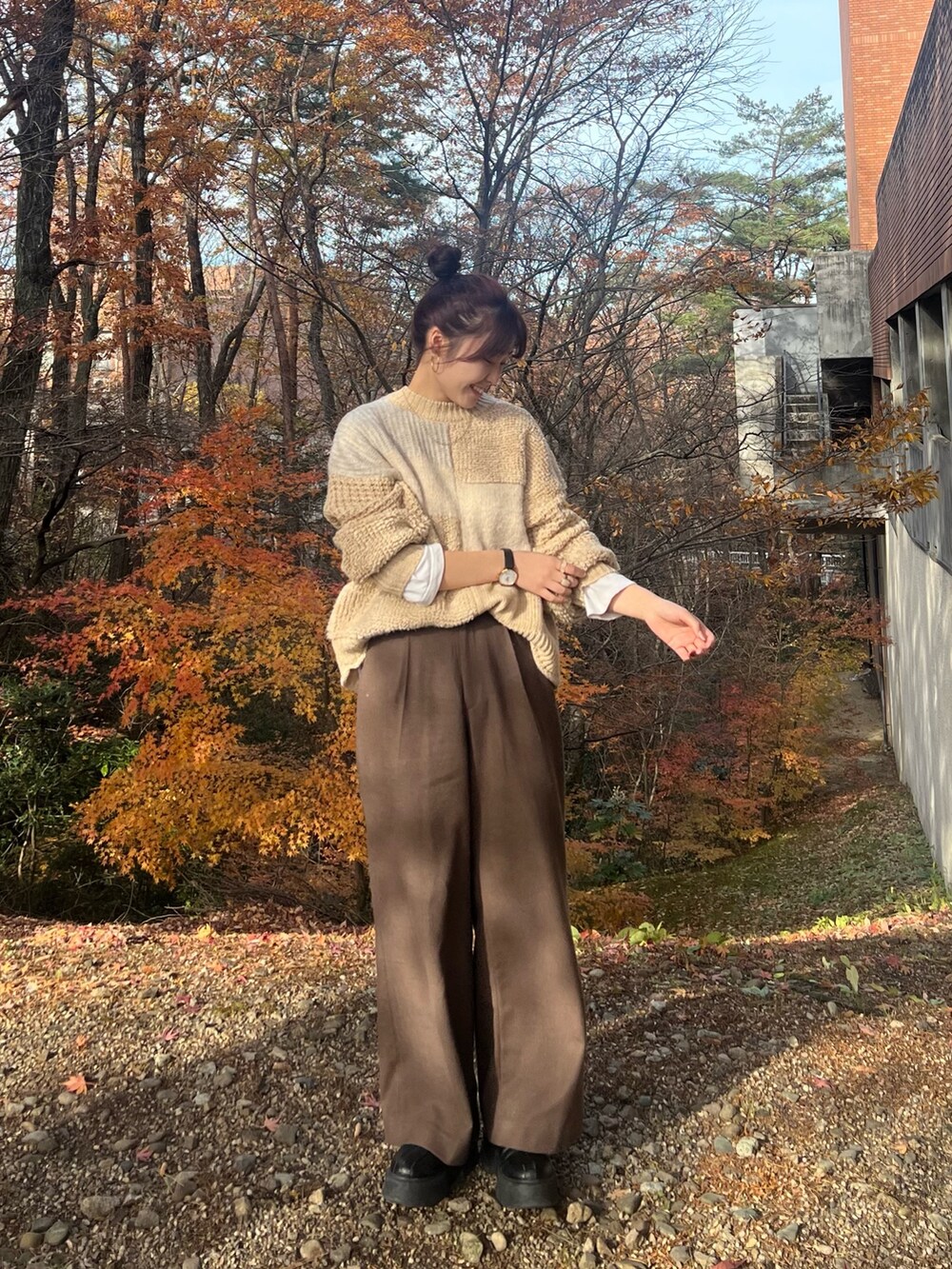 ホワイト系のニット/セーター、ブラウン系のその他パンツ、ブラック系のブーツを着用したレディースの冬コーディネートの5枚目の写真