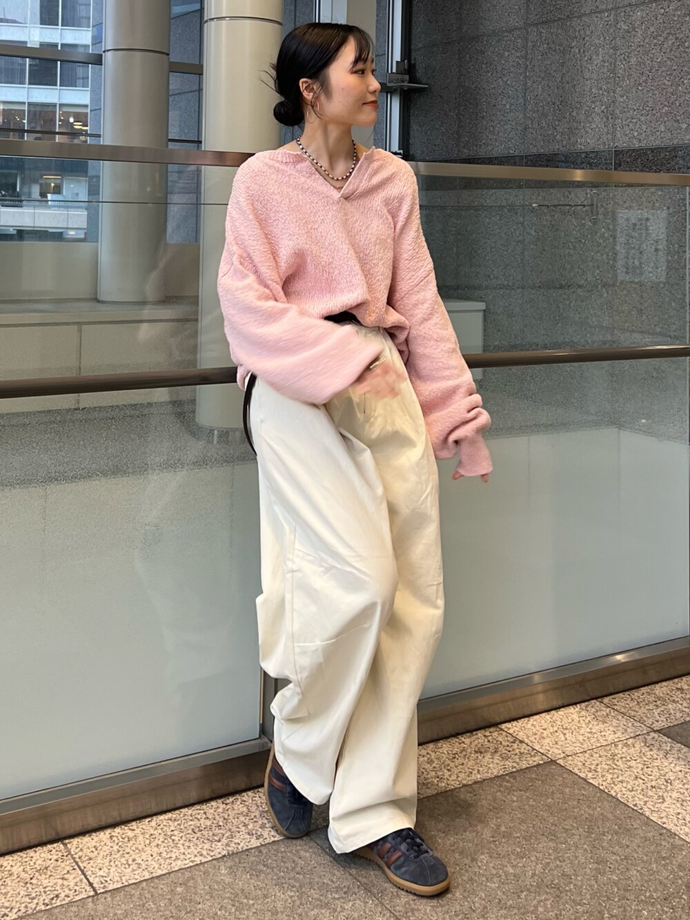 ホワイト系のチノパンツ、ピンク系のニット/セーター、ブラウン系のベルトを着用したレディースの冬コーディネートの2枚目の写真