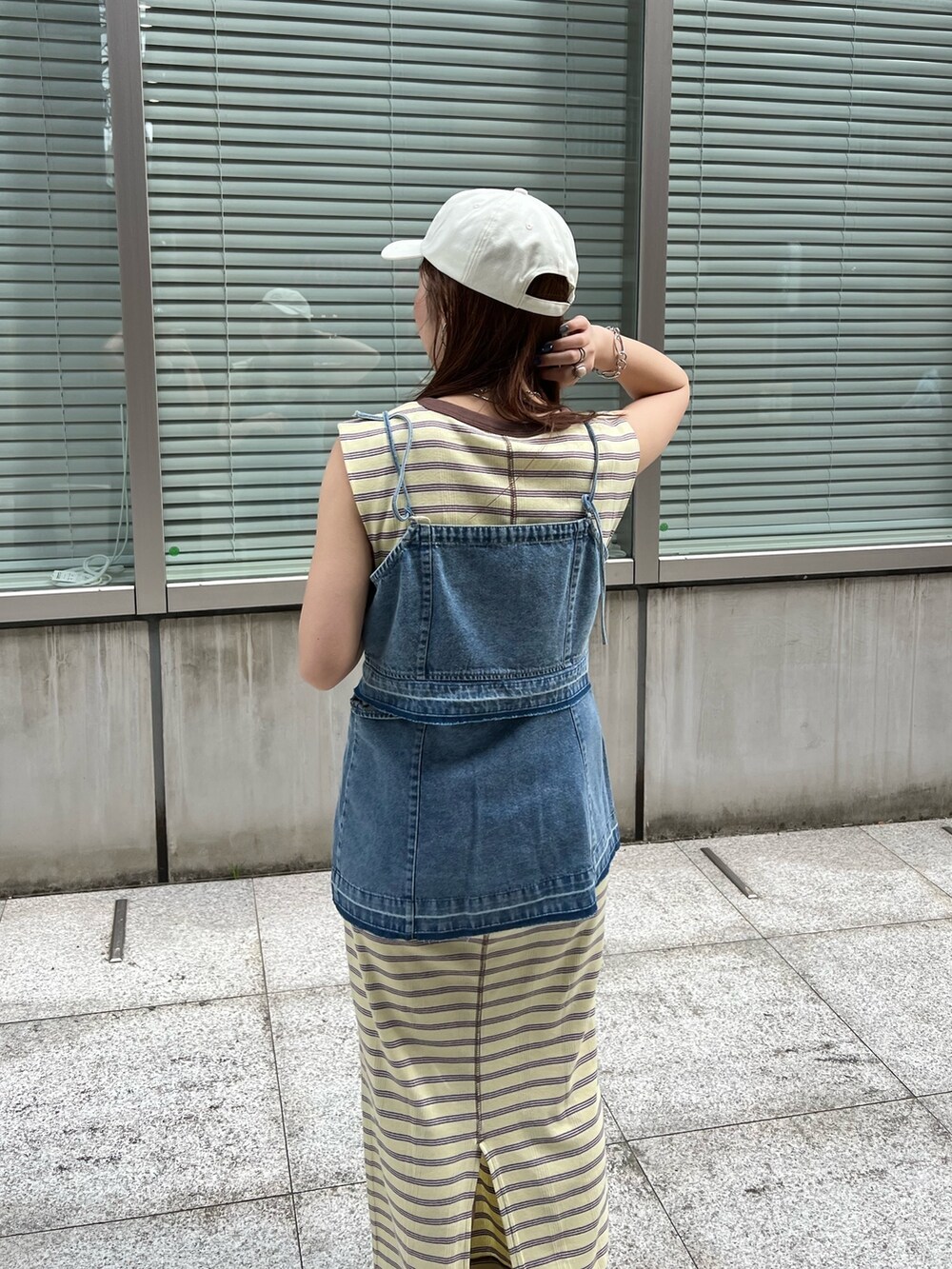 ブルー系のキャミソール、イエロー系のワンピース、ホワイト系のサンダルを着用したレディースの春コーディネートの5枚目の写真