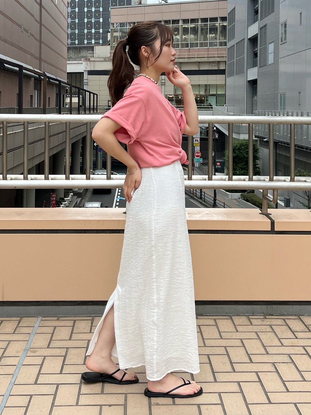 ホワイト系のスカート、ピンク系のTシャツ/カットソーを着用したレディースの夏コーディネートの2枚目の写真