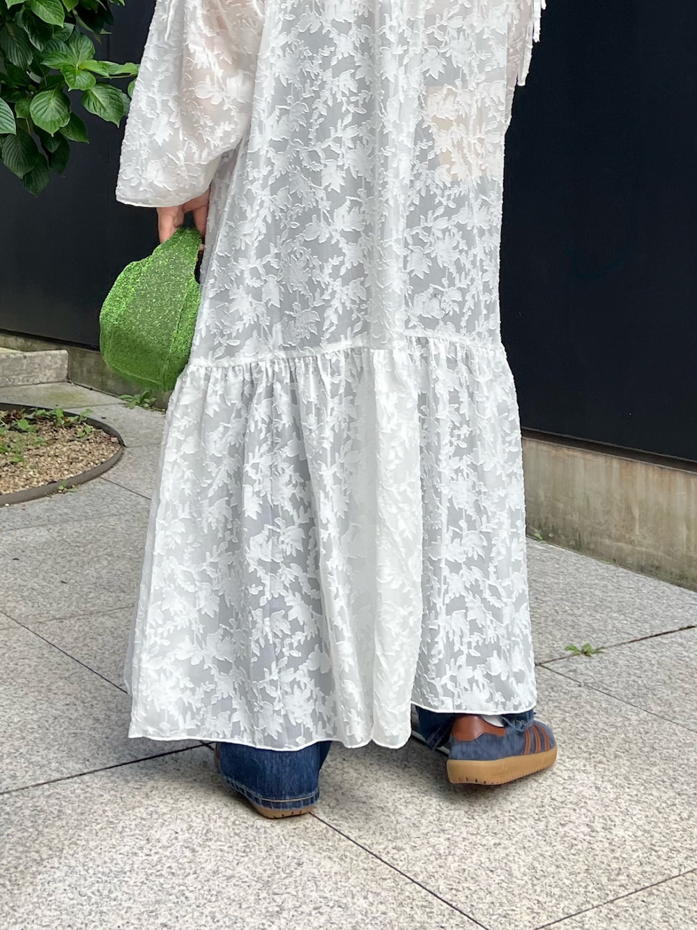 ホワイト系のワンピース、ブラック系のキャミソール、ブルー系のデニムパンツを着用したレディースの秋コーディネートの7枚目の写真