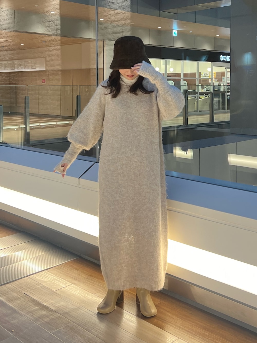 ホワイト系のワンピース、ベージュ系のブーツ、ホワイト系のTシャツ/カットソーを着用したレディースの冬コーディネートの2枚目の写真