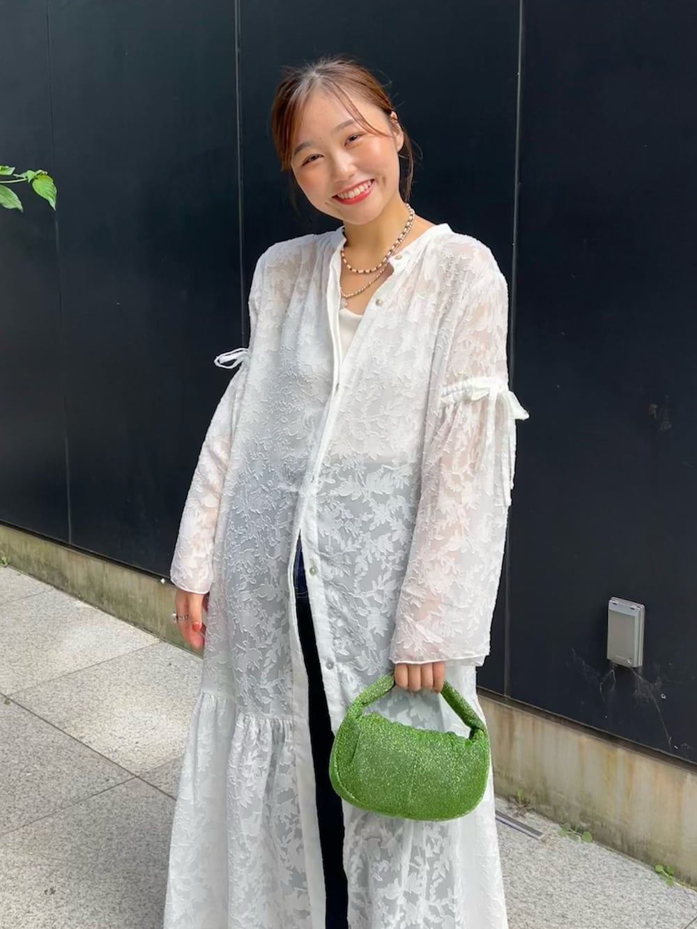 ホワイト系のワンピース、ブラック系のキャミソール、ブルー系のデニムパンツを着用したレディースの秋コーディネートの4枚目の写真