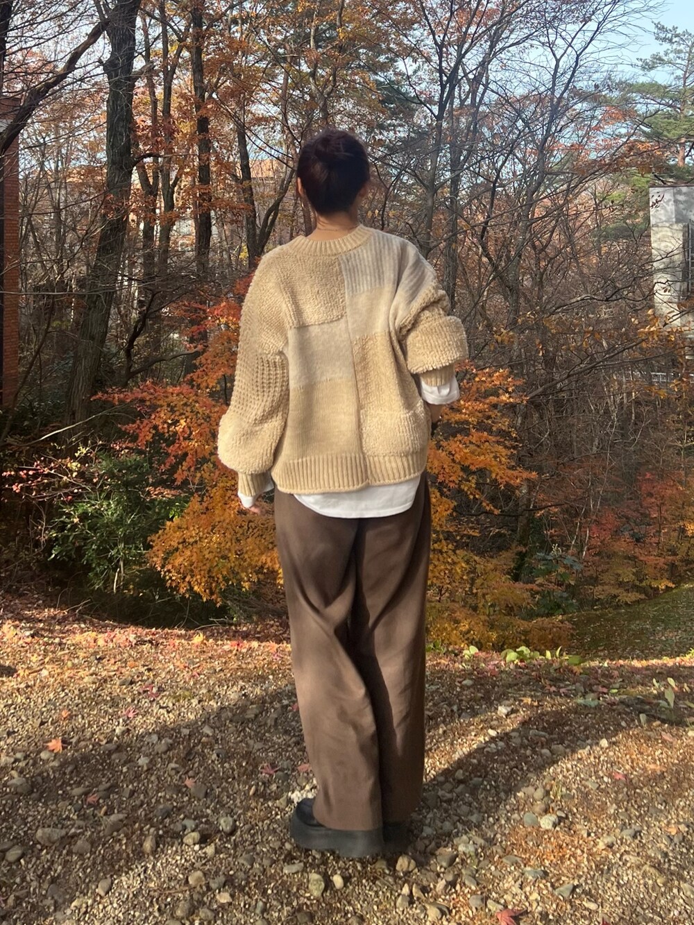 ホワイト系のニット/セーター、ブラウン系のその他パンツ、ブラック系のブーツを着用したレディースの冬コーディネートの3枚目の写真