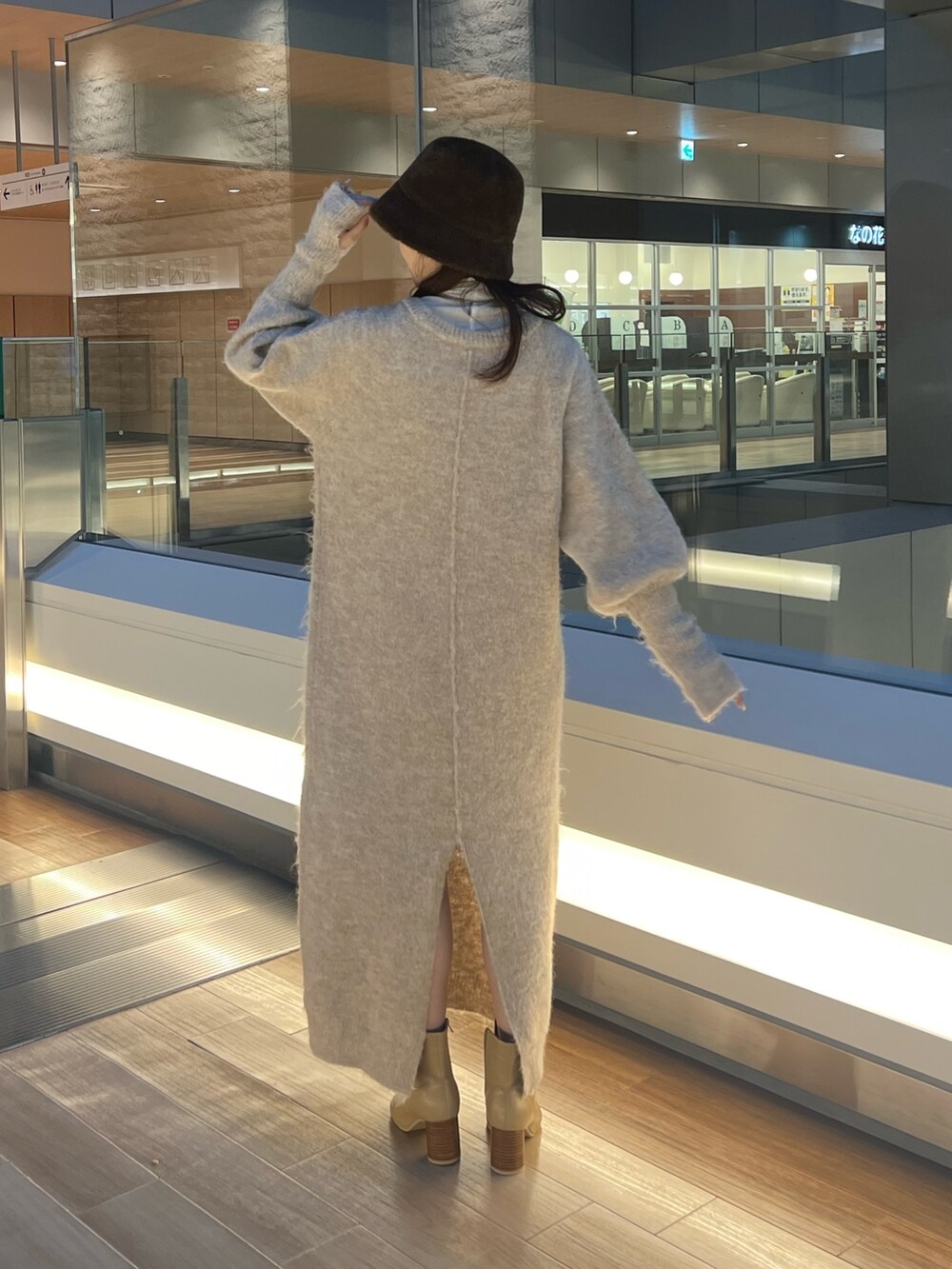 ホワイト系のワンピース、ベージュ系のブーツ、ホワイト系のTシャツ/カットソーを着用したレディースの冬コーディネートの3枚目の写真