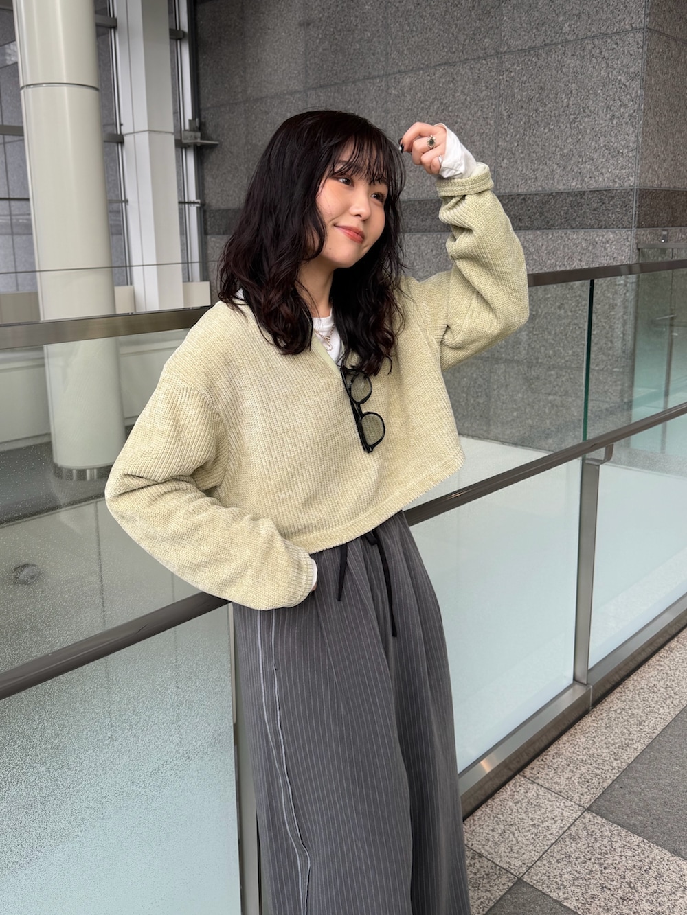 グレー系のその他パンツ、グリーン系のTシャツ/カットソー、ブラック系のスリッポンを着用したレディースの冬コーディネートの6枚目の写真