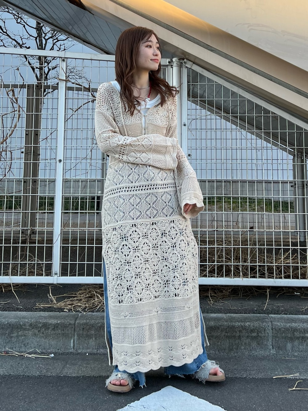 ホワイト系のワンピース、ホワイト系のTシャツ/カットソー、ホワイト系のサンダルを着用したレディースの春コーディネートの2枚目の写真