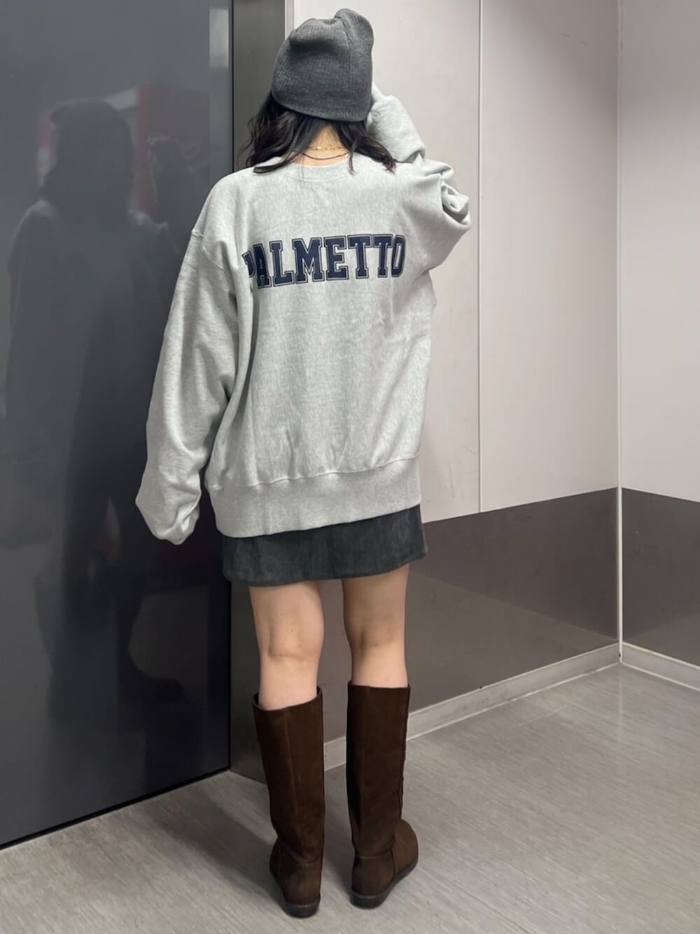 グレー系のスウェット、グレー系のスカート、ブラウン系のブーツを着用したレディースの秋コーディネートの3枚目の写真