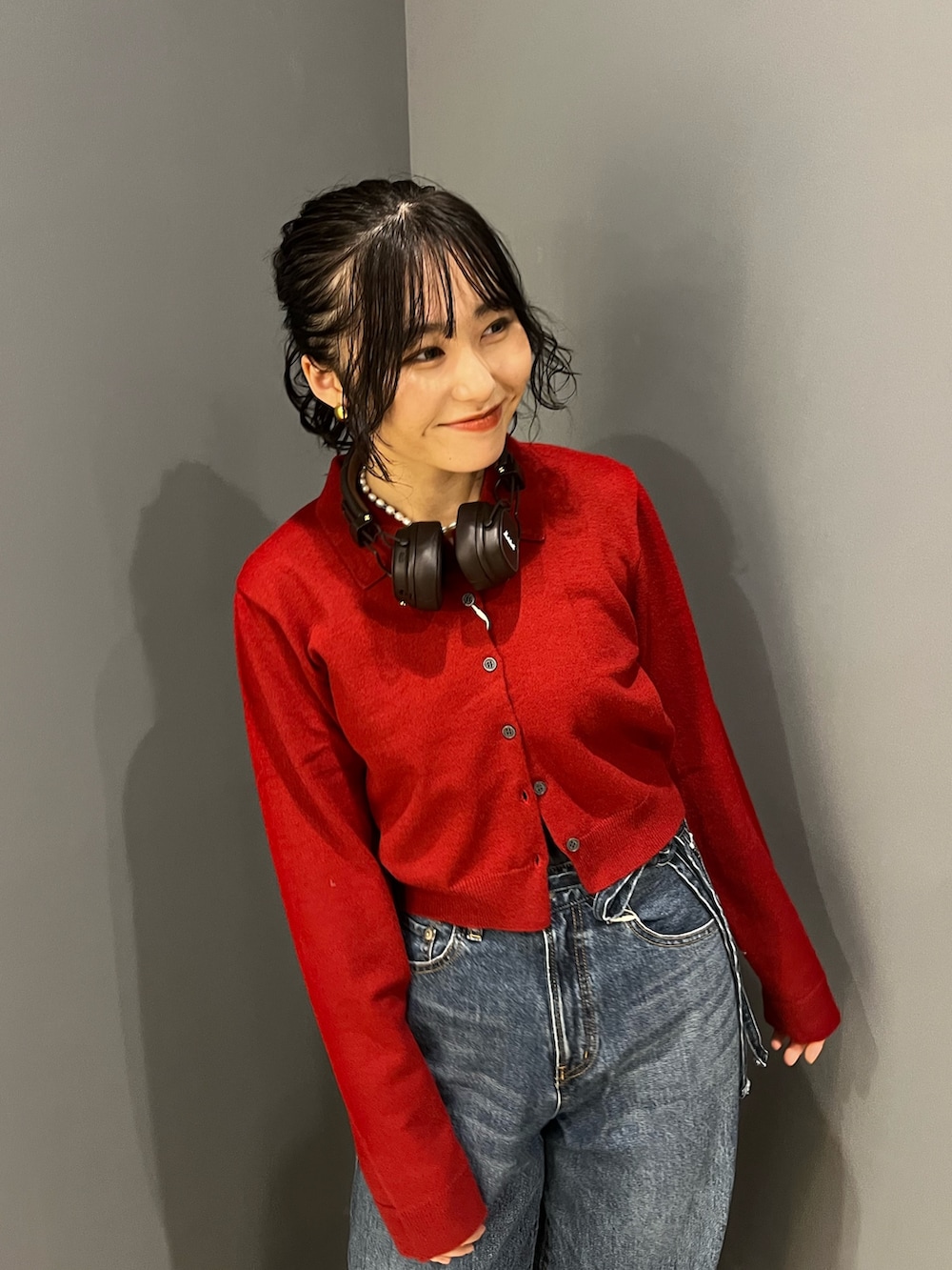 ブルー系のデニムパンツ、レッド系のカーディガン/ボレロを着用したレディースの秋コーディネートの4枚目の写真