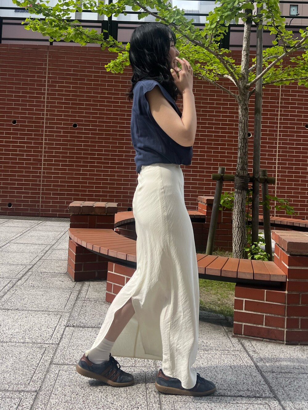 ホワイト系のスカート、ブルー系のタンクトップを着用したレディースの春コーディネートの2枚目の写真