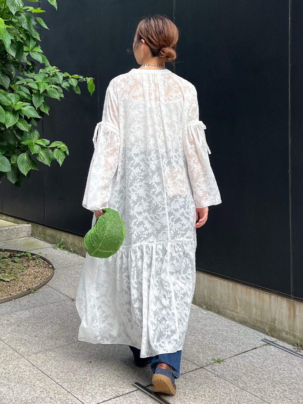 ホワイト系のワンピース、ブラック系のキャミソール、ブルー系のデニムパンツを着用したレディースの秋コーディネートの3枚目の写真