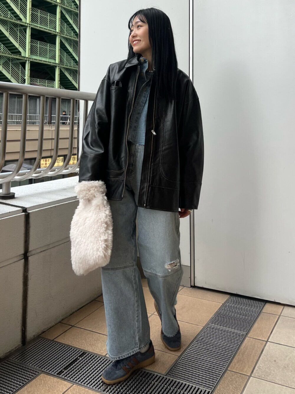 ブルー系のデニムパンツ、ブラック系のブルゾン、ブルー系のシャツ/ブラウスを着用したレディースの冬コーディネートの2枚目の写真