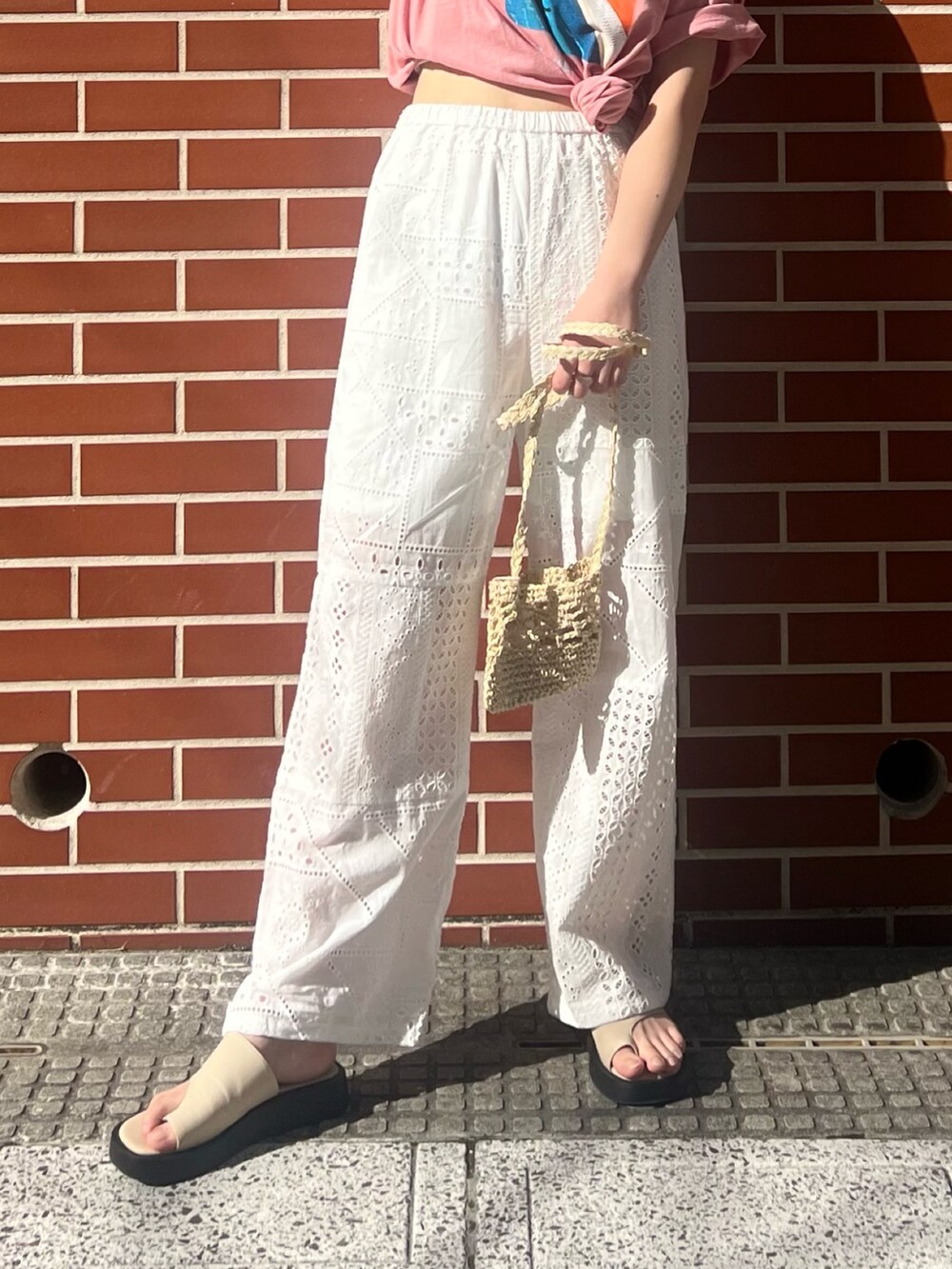 ホワイト系のその他パンツ、ベージュ系のショルダーバッグ、ピンク系のTシャツ/カットソーを着用したレディースの春コーディネートの7枚目の写真