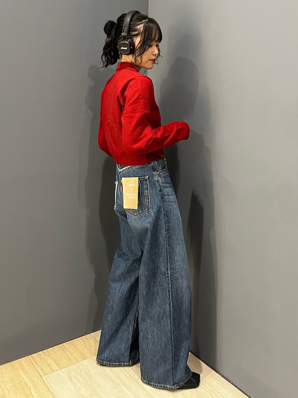 ブルー系のデニムパンツ、レッド系のカーディガン/ボレロを着用したレディースの秋コーディネートの2枚目の写真