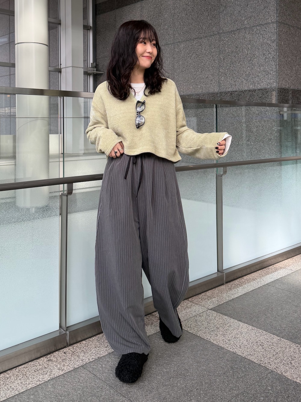 グレー系のその他パンツ、グリーン系のTシャツ/カットソー、ブラック系のスリッポンを着用したレディースの冬コーディネートの3枚目の写真