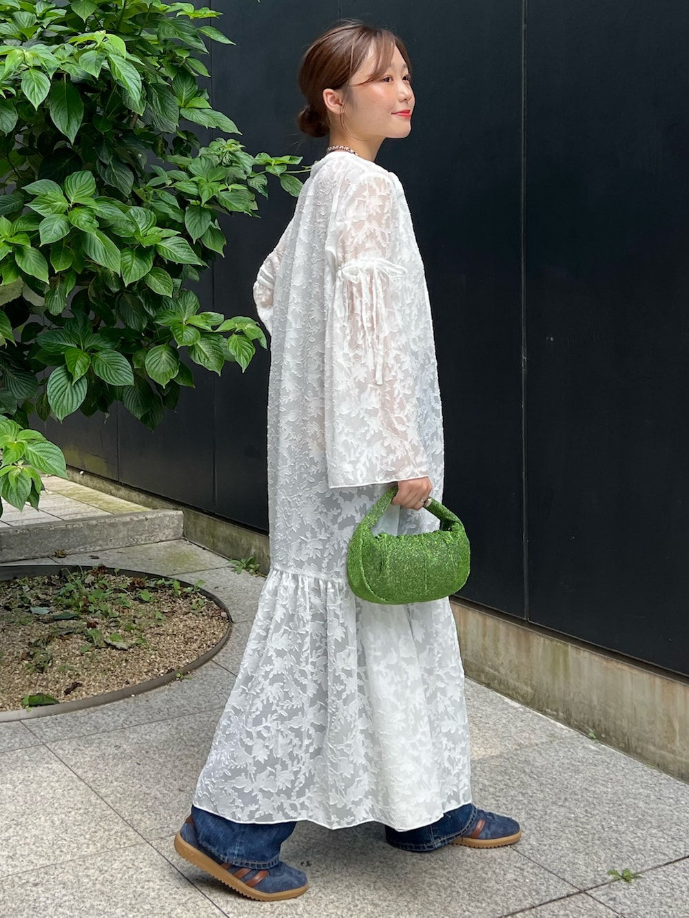 ホワイト系のワンピース、ブラック系のキャミソール、ブルー系のデニムパンツを着用したレディースの秋コーディネートの2枚目の写真