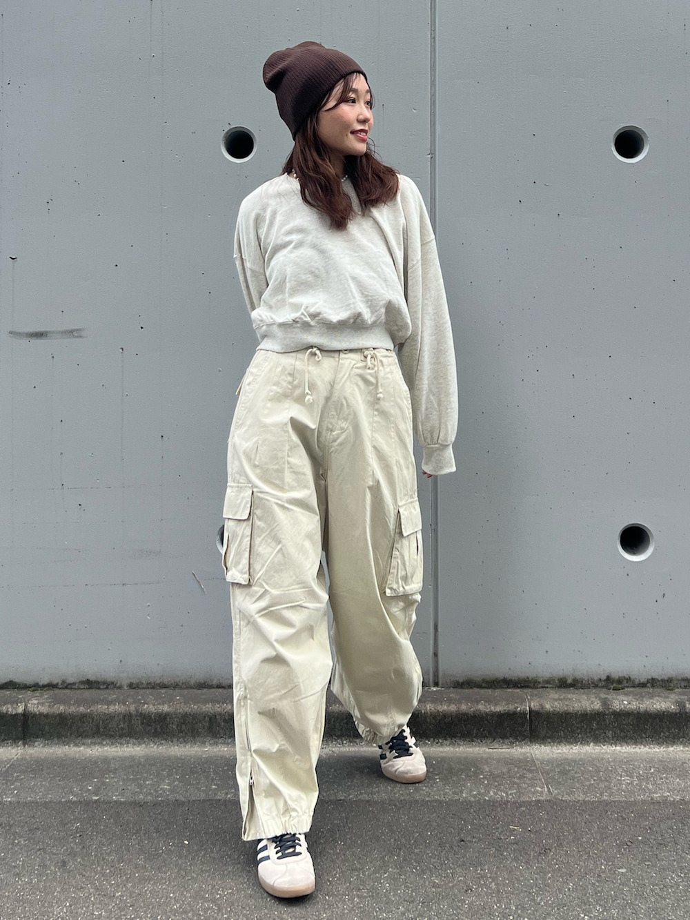 ホワイト系のカーゴパンツ、グレー系のスウェット、ブラウン系のニットキャップ/ビーニーを着用したレディースの秋コーディネートの2枚目の写真