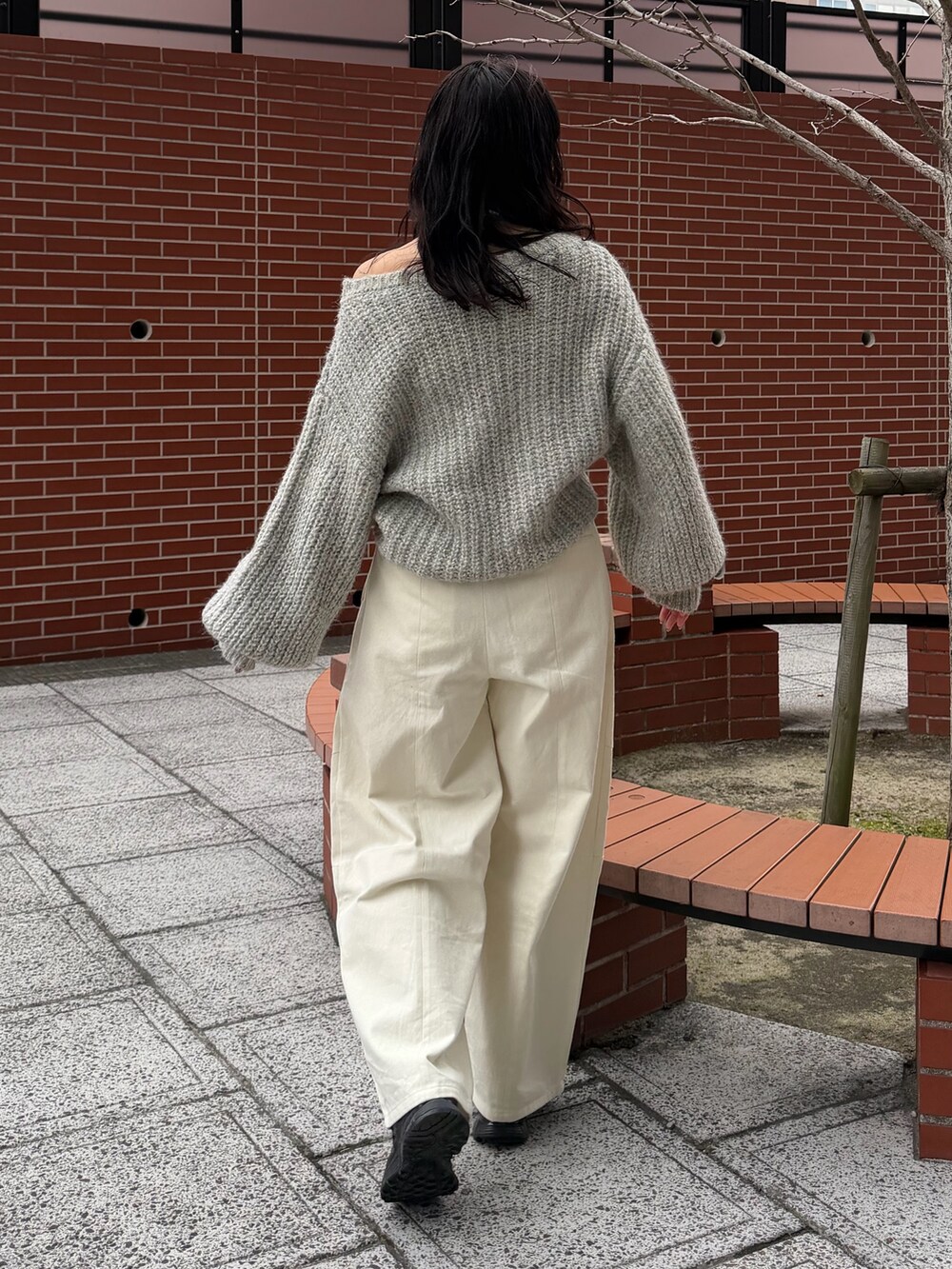 ホワイト系のチノパンツ、グレー系のニット/セーター、ブラック系のベルトを着用したレディースの冬コーディネートの3枚目の写真