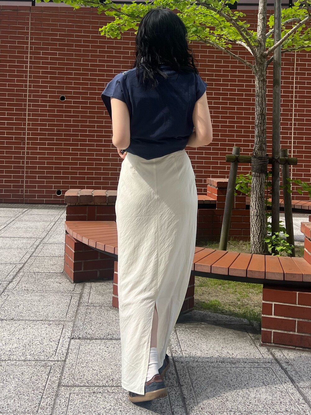 ホワイト系のスカート、ブルー系のタンクトップを着用したレディースの春コーディネートの3枚目の写真