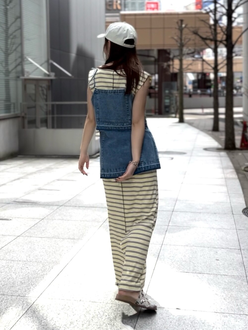 ブルー系のキャミソール、イエロー系のワンピース、ホワイト系のサンダルを着用したレディースの春コーディネートの3枚目の写真