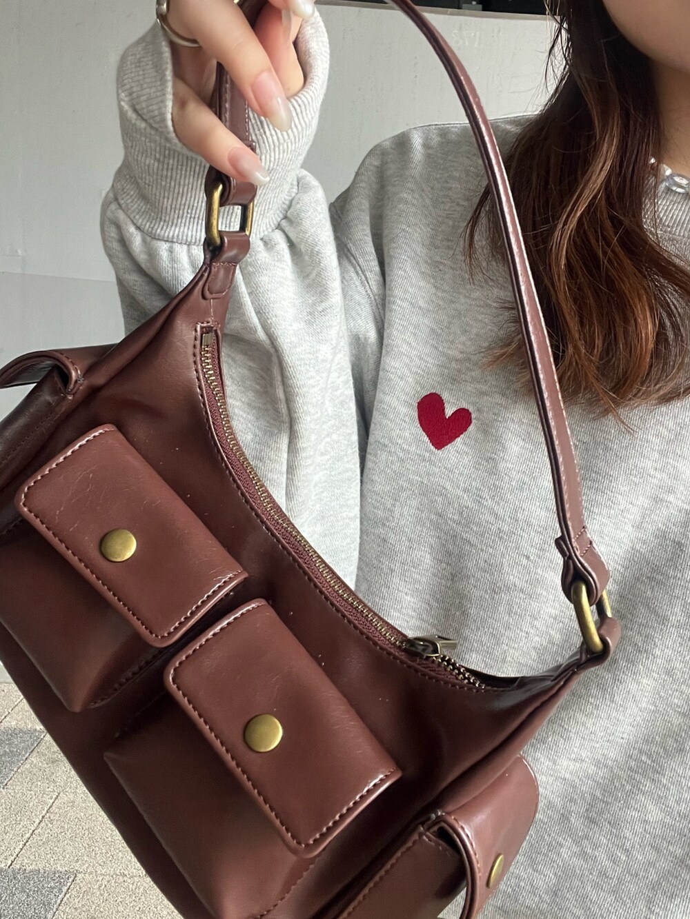 イエロー系のスカート、グレー系のスウェット、ブラウン系のハンドバッグを着用したレディースの夏コーディネートの5枚目の写真