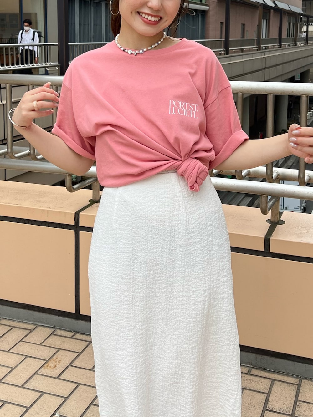 ホワイト系のスカート、ピンク系のTシャツ/カットソーを着用したレディースの夏コーディネートの4枚目の写真