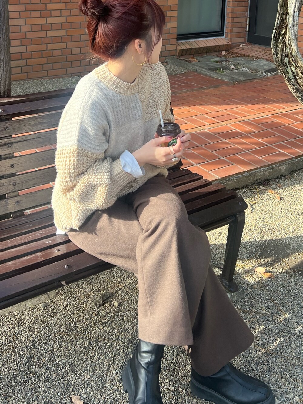 ホワイト系のニット/セーター、ブラウン系のその他パンツ、ブラック系のブーツを着用したレディースの冬コーディネートの6枚目の写真