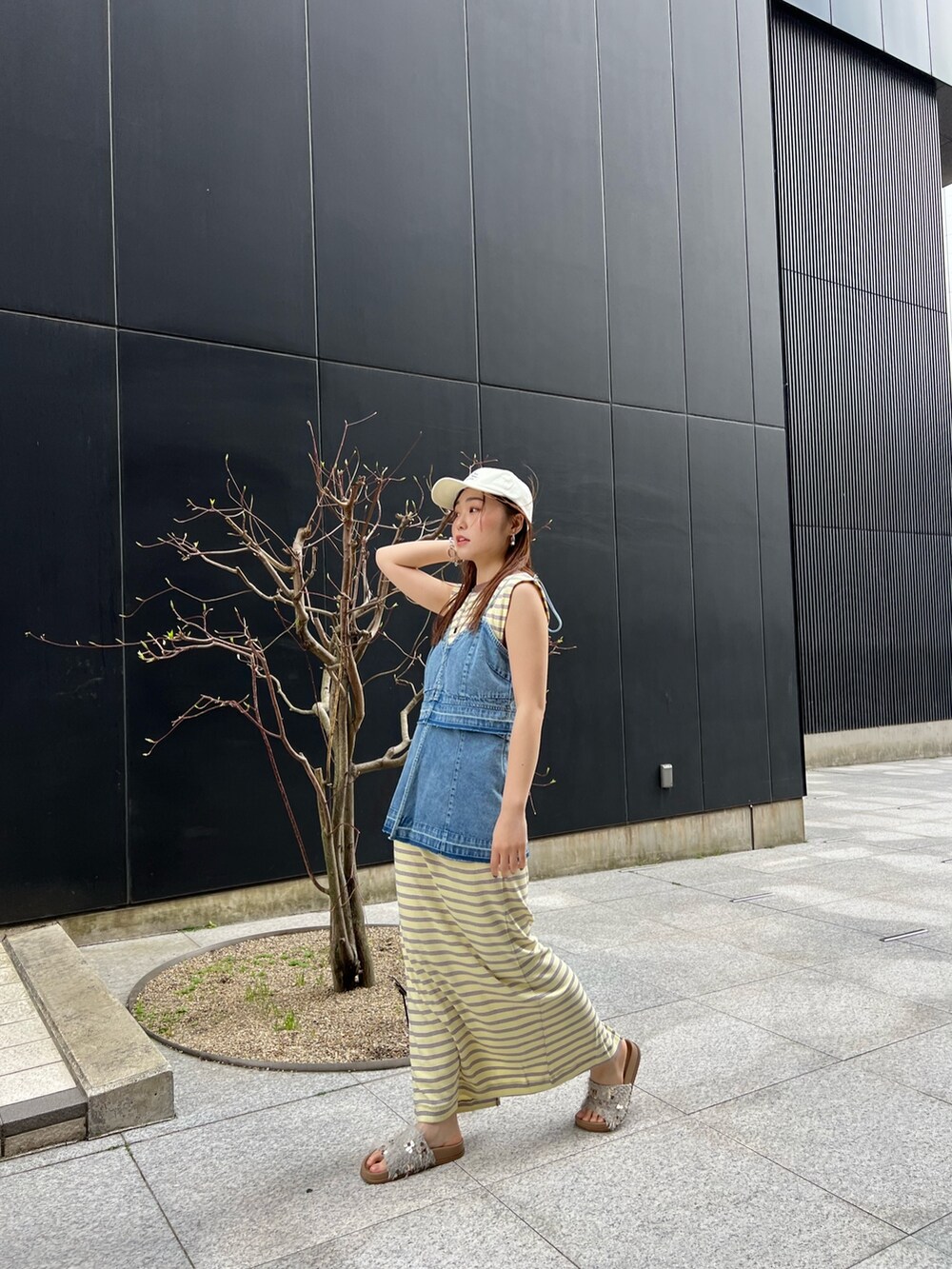 ブルー系のキャミソール、イエロー系のワンピース、ホワイト系のサンダルを着用したレディースの春コーディネートの2枚目の写真