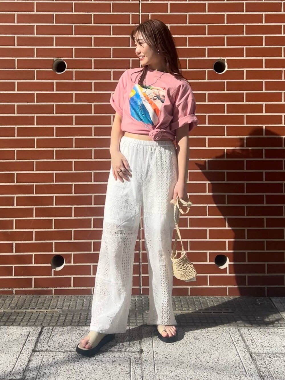 ホワイト系のその他パンツ、ベージュ系のショルダーバッグ、ピンク系のTシャツ/カットソーを着用したレディースの春コーディネートの2枚目の写真