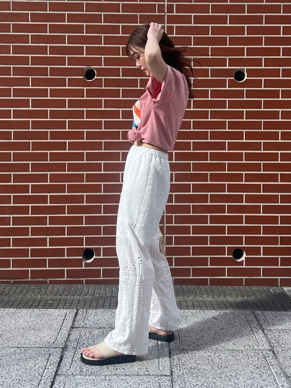 ホワイト系のその他パンツ、ベージュ系のショルダーバッグ、ピンク系のTシャツ/カットソーを着用したレディースの春コーディネートの3枚目の写真