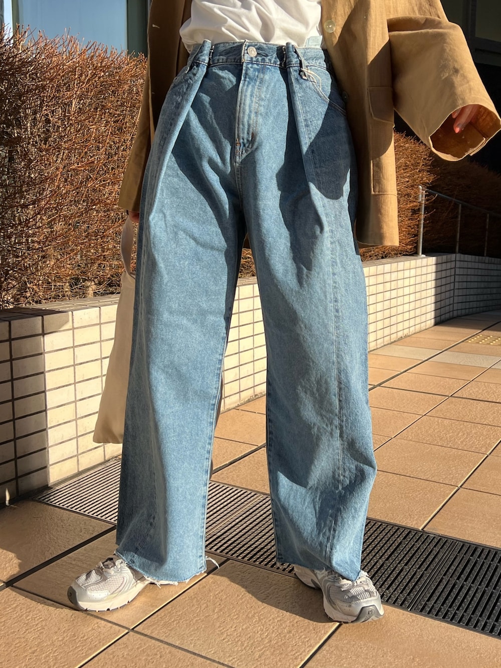 ブルー系のデニムパンツ、レッド系のトートバッグ、ベージュ系のテーラードジャケットを着用したレディースの春コーディネートの7枚目の写真