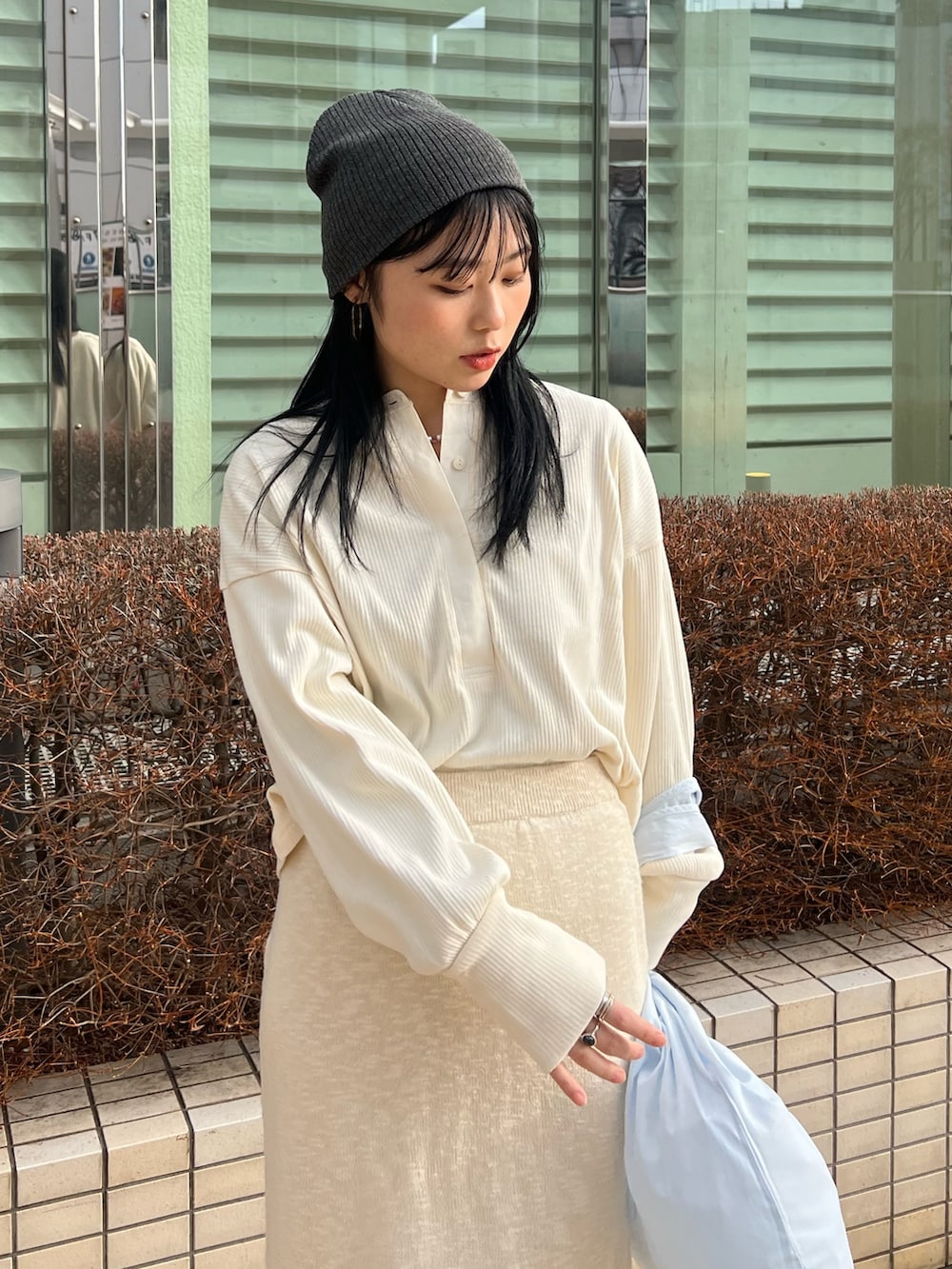 ホワイト系のスカート、ホワイト系のTシャツ/カットソー、ブルー系のエコバッグ/サブバッグを着用したレディースの冬コーディネートの5枚目の写真