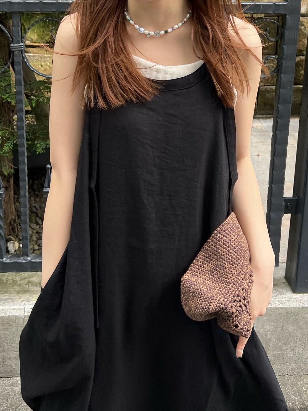 ブラック系のワンピース、ブルー系のデニムパンツ、ホワイト系のキャミソールを着用したレディースの夏コーディネートの6枚目の写真