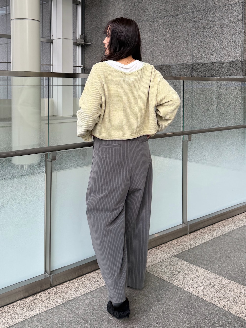 グレー系のその他パンツ、グリーン系のTシャツ/カットソー、ブラック系のスリッポンを着用したレディースの冬コーディネートの5枚目の写真