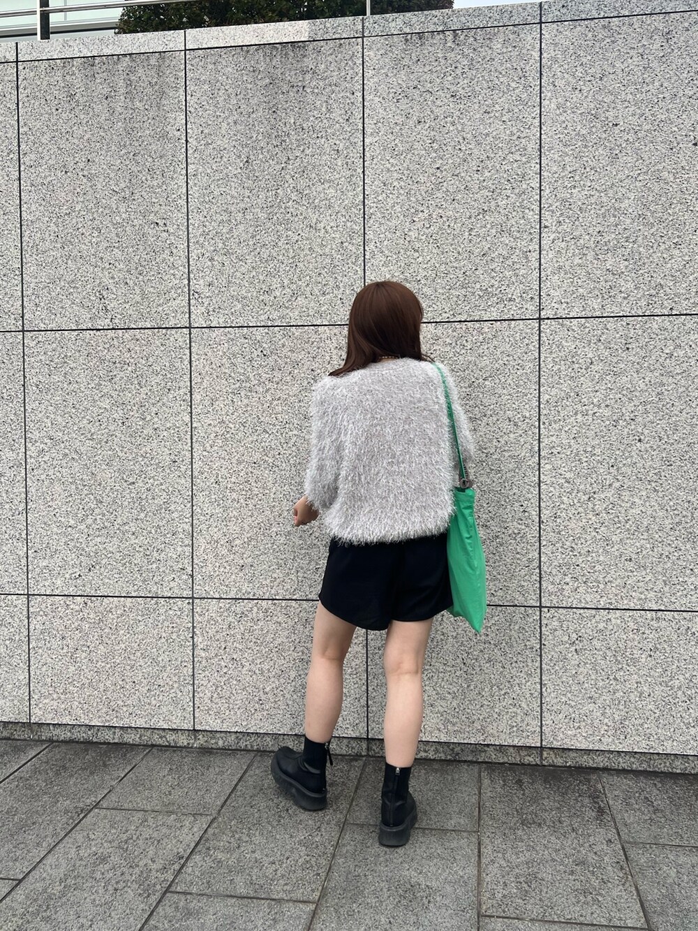 シルバー系のニット/セーター、ブラック系のブーツを着用したレディースの秋コーディネートの2枚目の写真