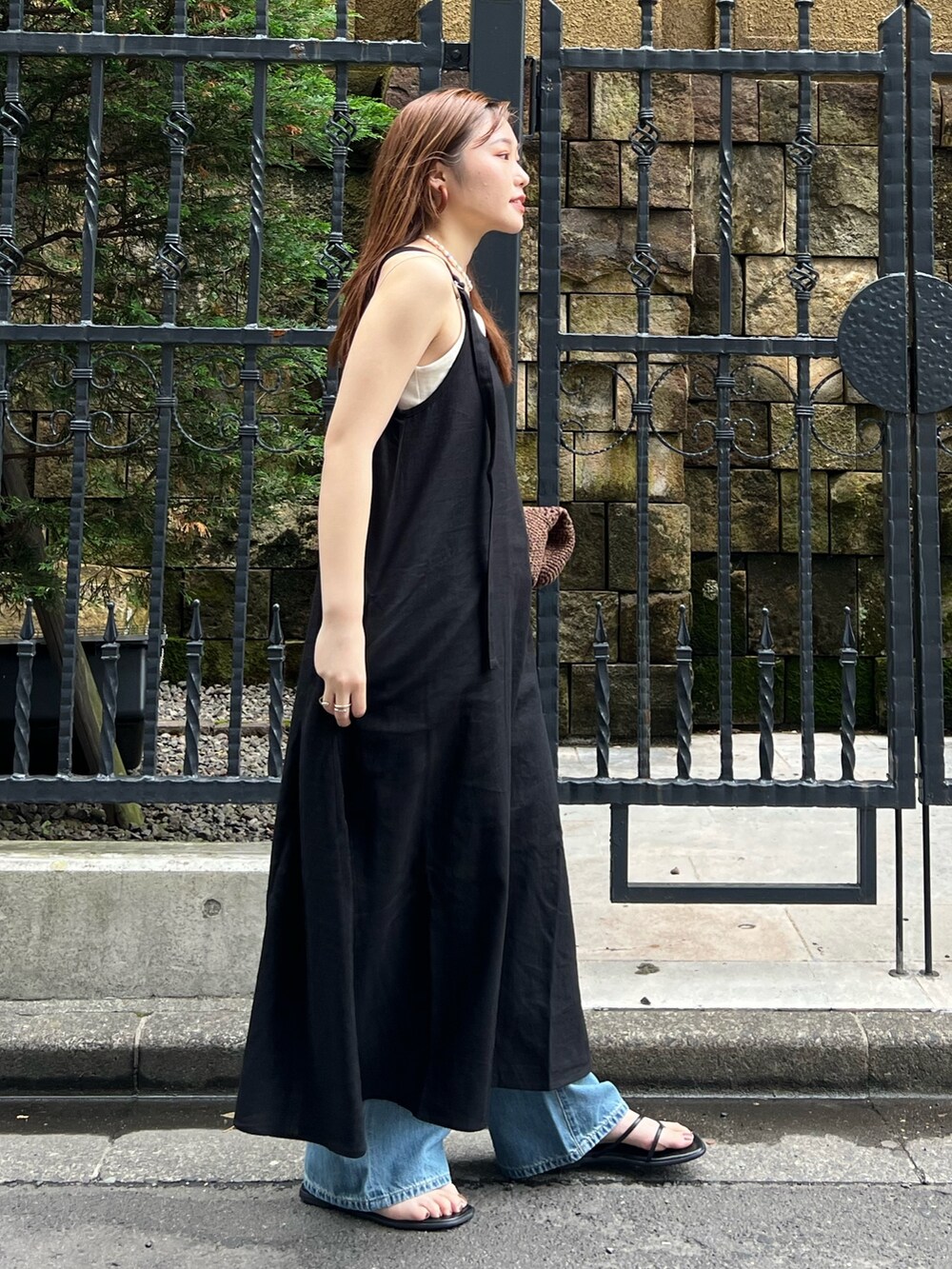 ブラック系のワンピース、ブルー系のデニムパンツ、ホワイト系のキャミソールを着用したレディースの夏コーディネートの4枚目の写真