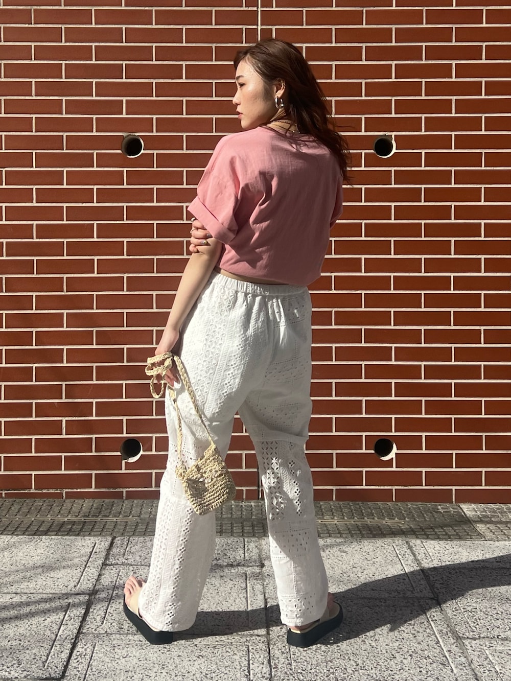 ホワイト系のその他パンツ、ベージュ系のショルダーバッグ、ピンク系のTシャツ/カットソーを着用したレディースの春コーディネートの4枚目の写真