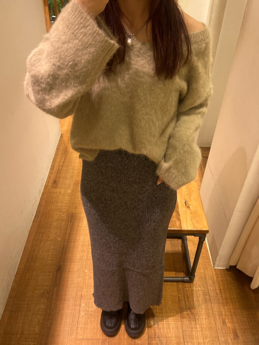 グレー系のニット/セーター、グレー系のスカート、ブラック系のブーツを着用したレディースの冬コーディネートの3枚目の写真