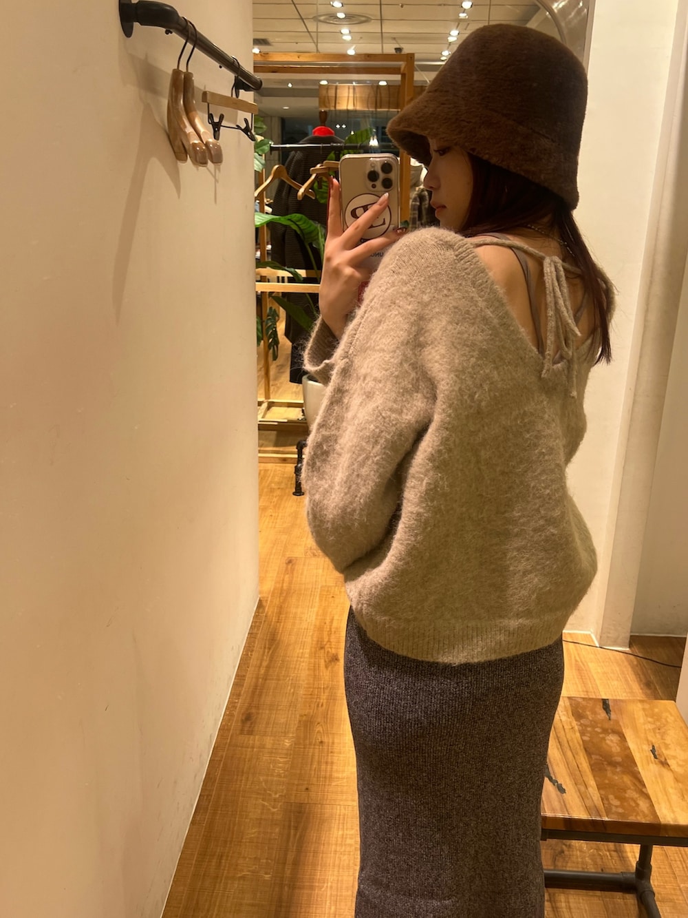 グレー系のニット/セーター、グレー系のスカート、ブラック系のブーツを着用したレディースの冬コーディネートの4枚目の写真