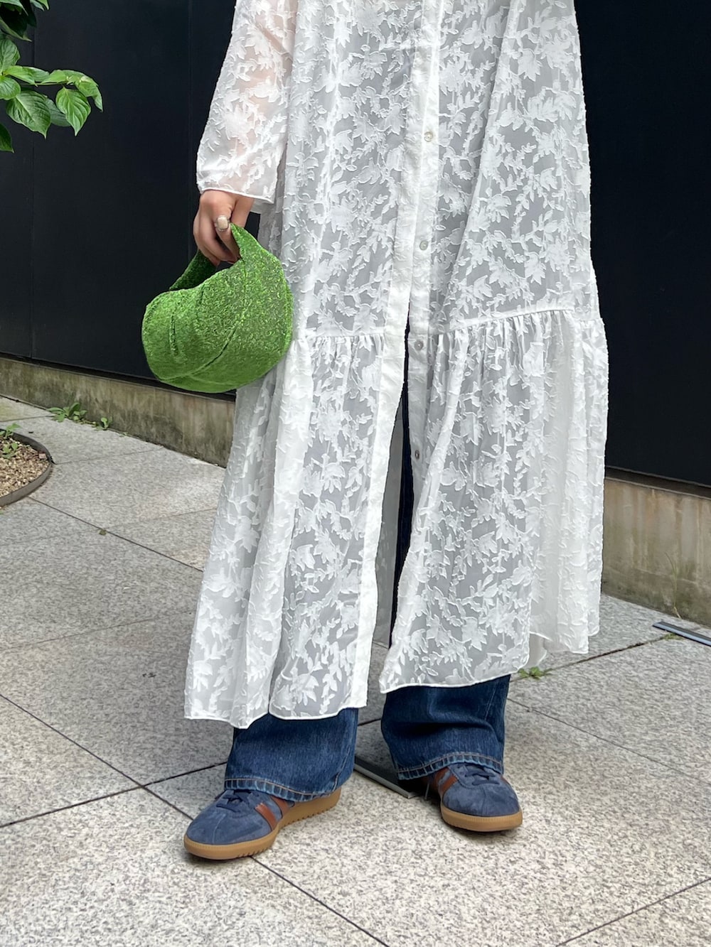 ホワイト系のワンピース、ブラック系のキャミソール、ブルー系のデニムパンツを着用したレディースの秋コーディネートの5枚目の写真