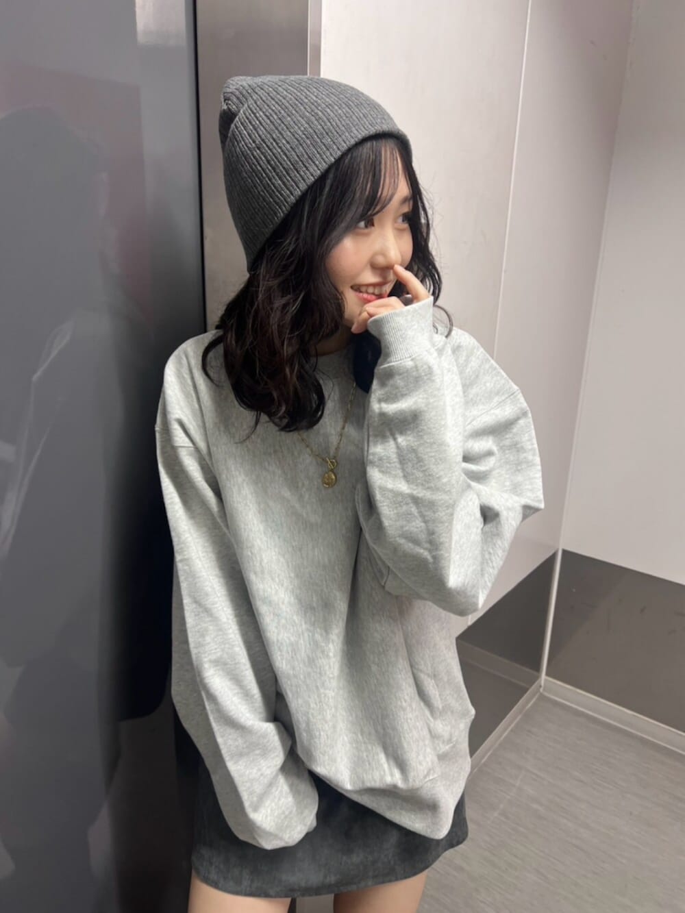 グレー系のスウェット、グレー系のスカート、ブラウン系のブーツを着用したレディースの秋コーディネートの5枚目の写真