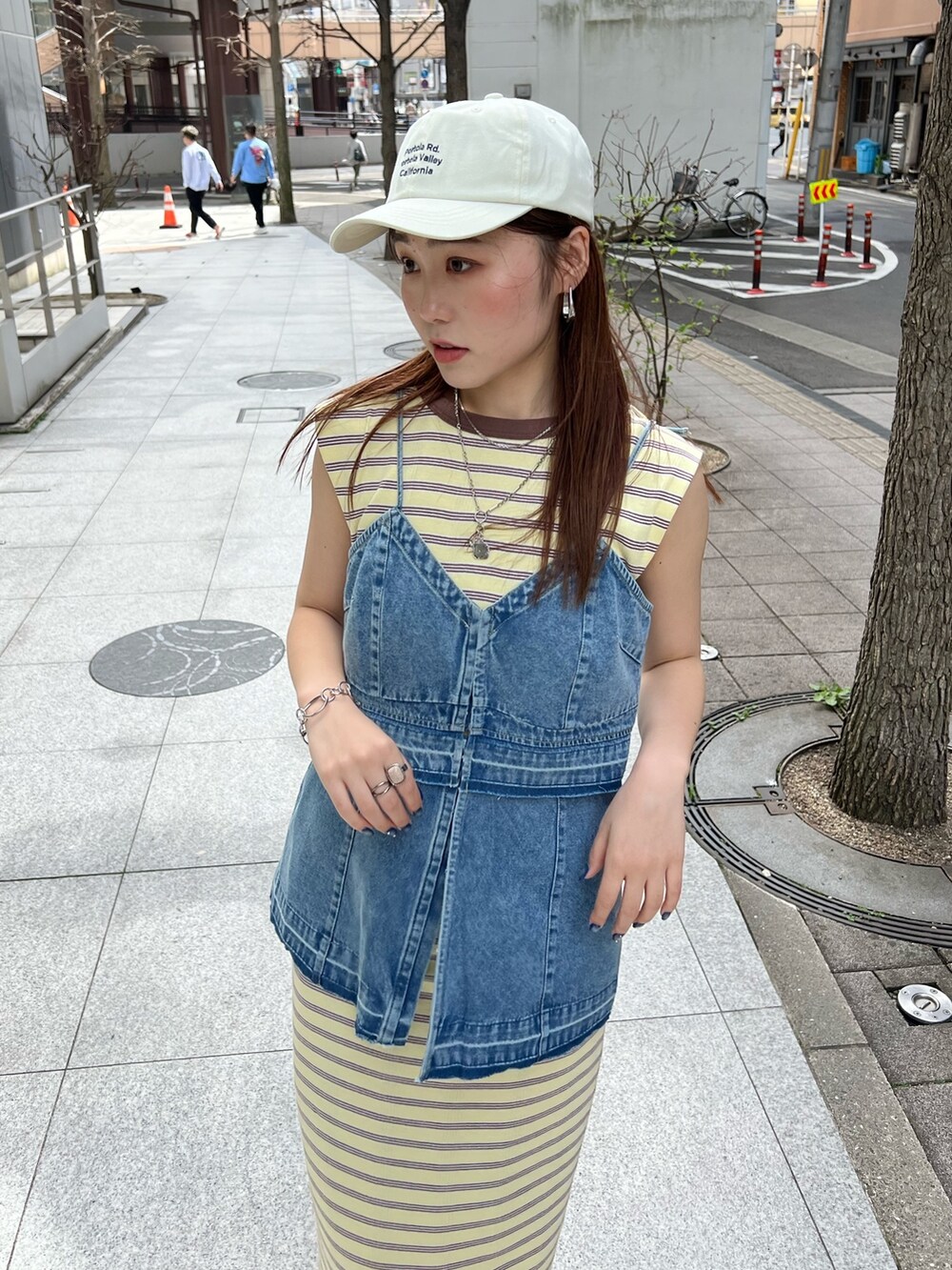 ブルー系のキャミソール、イエロー系のワンピース、ホワイト系のサンダルを着用したレディースの春コーディネートの4枚目の写真